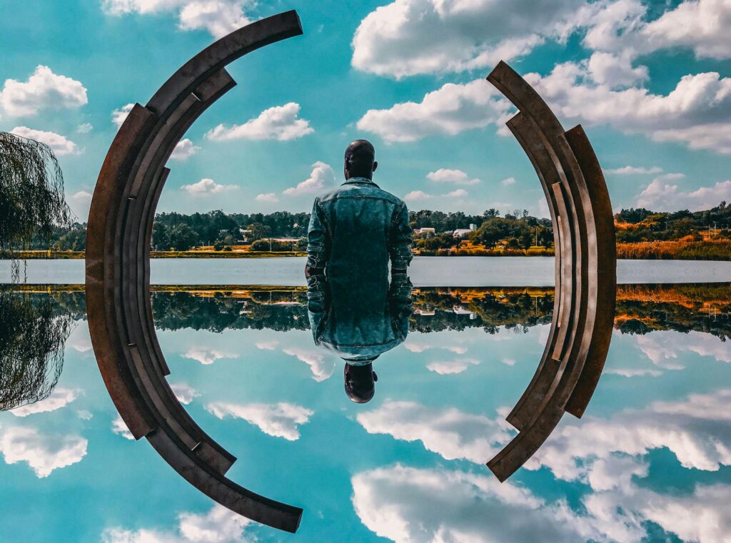 Man looking at a beatiful scenery of a lake and a forest