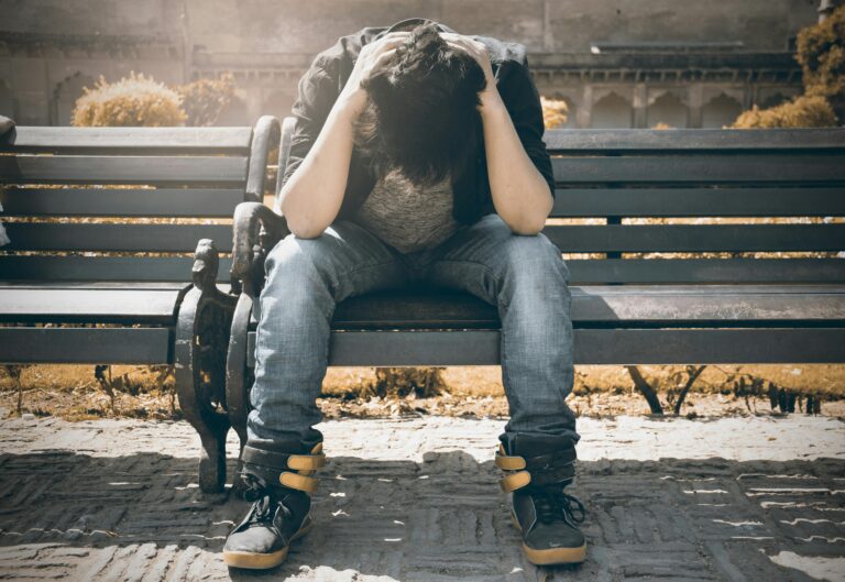 Man sitting on a bench without any motivation to work out